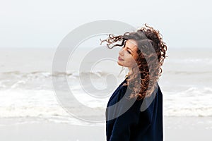 Girl rain sea wind winter portrait woman smile spring coat long hair curly mood shore snow beach