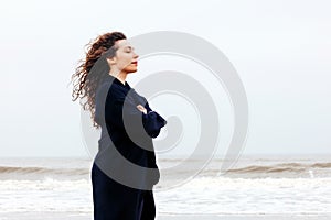 Girl rain sea wind winter portrait woman smile spring coat long hair curly mood shore snow beach