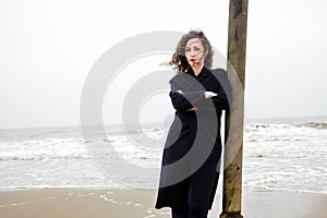 Girl rain sea wind winter portrait woman smile spring coat long hair curly mood shore snow beach autumn deadpan