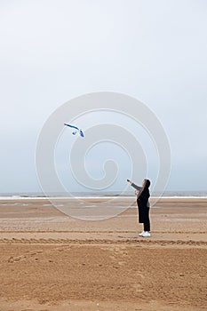 Girl rain sea wind winter portrait woman smile spring coat long hair curly mood shore snow beach kite