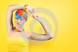 Girl with rainbow colorful fashion makeup on yellow background.