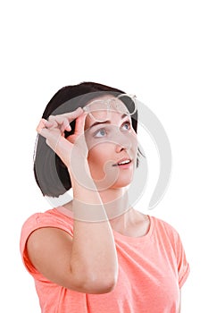 Girl raised her glasses and looks up on a white isolated background