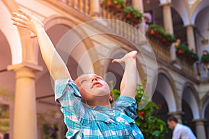 The girl raises her arms admiringly up to the sunlight