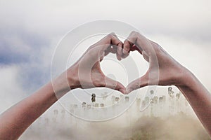 The girl raises her hand to signify a meaningful sign language. Tell your lover that I love you on a blurred background of nature