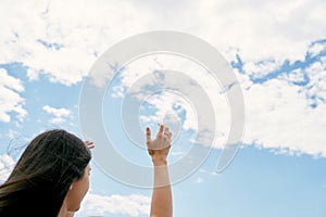 Girl raises her hands to the sky. Praying to God. Close-up