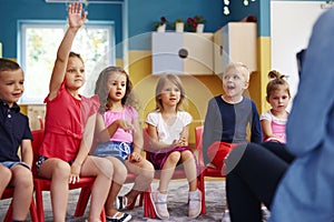 Girl raising her hand to ask question in classroom