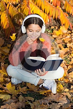Girl read book autumn day. Little child enjoy learning at backyard. Kid study with book. Self education concept. Child