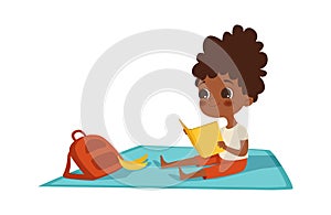 Girl reading. Afroamerican child with book and backpack sits on plaid. Summer activity, self education and entertainment