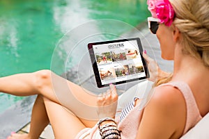 Girl reading blog on tablet by the pool. All contents are made up.
