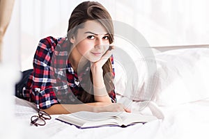 Girl reading a book in bed,