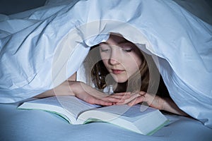 Girl Reading Book In Bedroom
