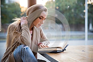 Girl reading book in cafe