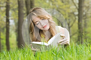 Girl reading book on grass