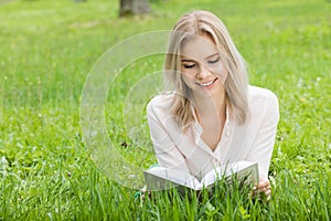 Girl reading book on grass