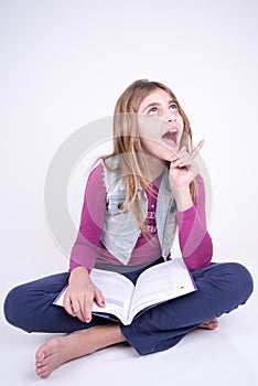 Girl reading a book and having an idea