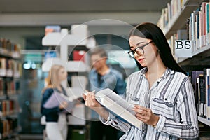 Girl Reading Book In Library. Student Learning