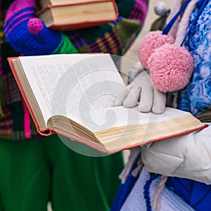 A girl is reading a book. Opened book in the hands of a young woman. Educational process. Lecture for students or poetic, literary