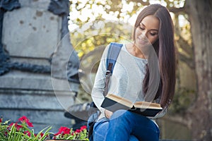 Girl reading book outdoors