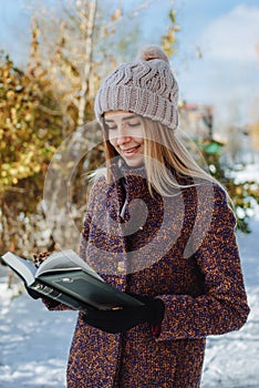 Girl reading book outdoors in winter