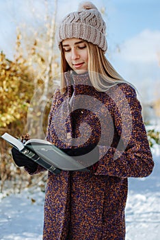 Girl reading book outdoors in winter