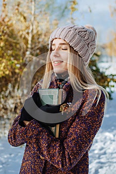 Girl reading book outdoors in winter