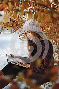 Girl reading book outdoors in winter