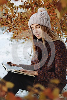 Girl reading book outdoors in winter