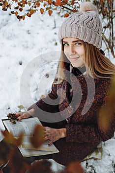 Girl reading book outdoors in winter