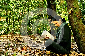 Girl reading a book in a park