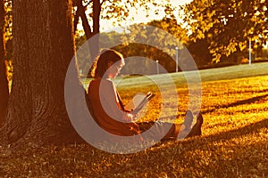 Girl reading book at park