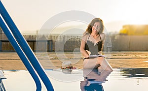 Girl reading a book by the pool