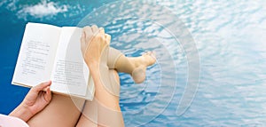 Girl reading a book by the pool