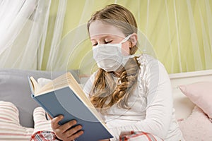 Girl reading a book during quarantine on the bed