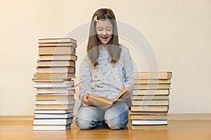 Girl reading a book sitting on the floor in an apartment. Cute girl reading book at home. education and school concept - little