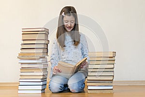 Girl reading a book sitting on the floor in an apartment. Cute girl reading book at home. education and school concept - little