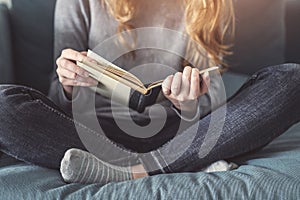 Girl reading a book on sofa