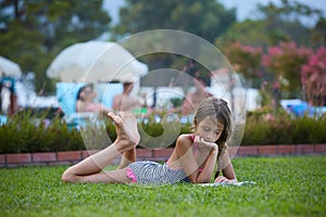 Girl are reading book at summer meadow