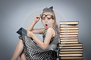 Girl reading a book and is very surprised