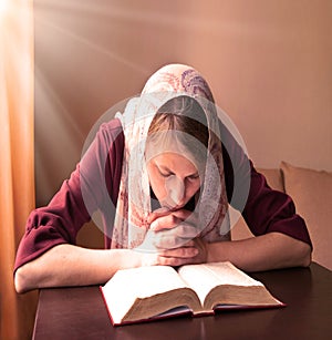 Girl reading a book by the window