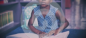 Girl reading braille book in library