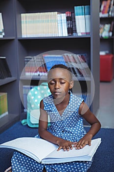 Girl reading braille in library photo