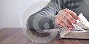 Girl reading the Holy Bible in the wooden table