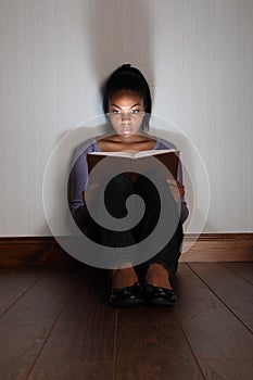 Girl reading horror story book looking frightened