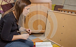 Girl reading instructions to assemble furniture