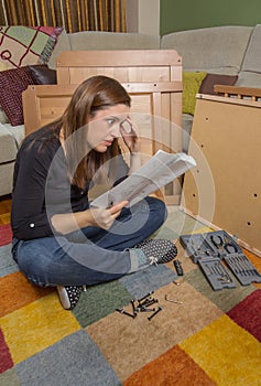 Girl reading instructions to assemble furniture