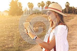 Girl reading ltablet in countryside