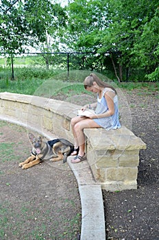 Girl Reading in Park with Dog