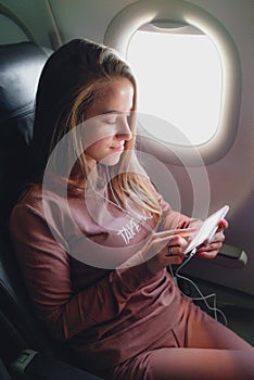 Girl is reading from smartphone in airplane