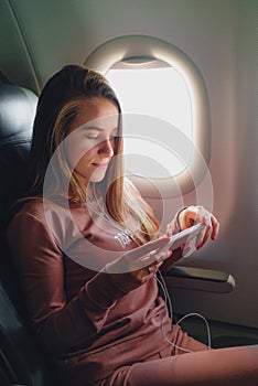 Girl is reading from smartphone in airplane
