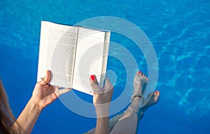 Girl reading by the swimming pool